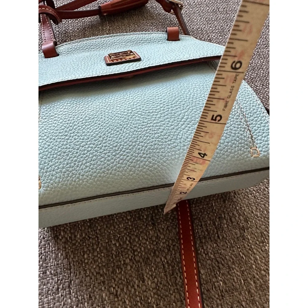 This is a Dooney & Bourke Pebble Grain East/West Flap Crossbody in a light blue